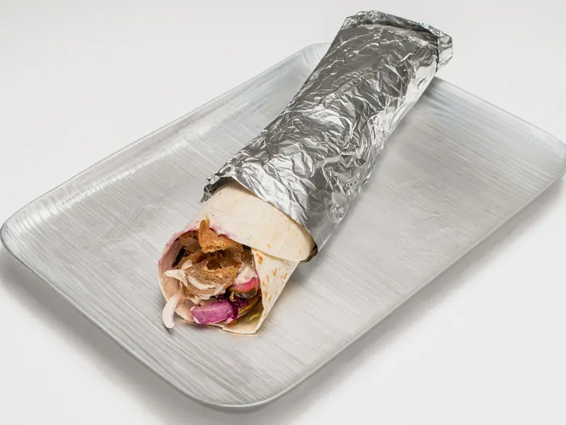 Kebabrulle inslagen i folie på en bricka